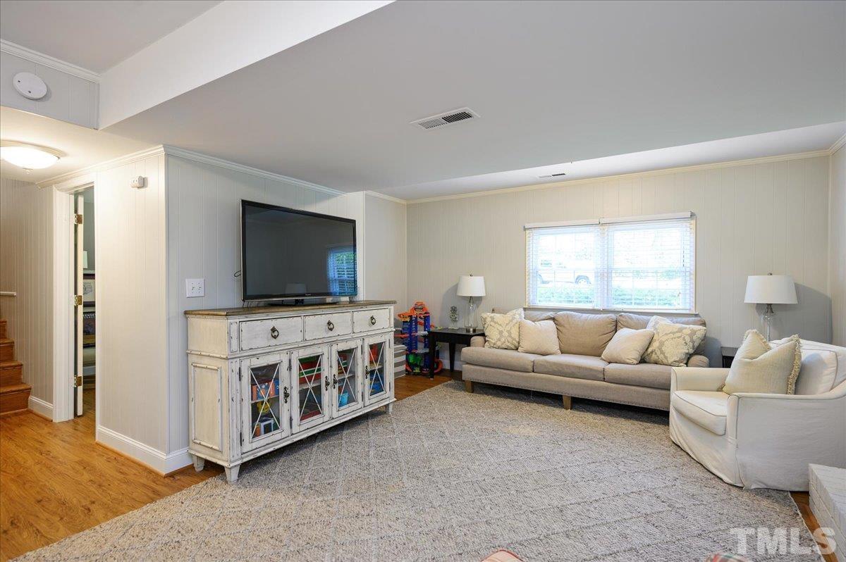 7509 Harps Mill Road Raleigh, NC 27615 - Photo 29 of 31 a living room with furniture and a flat screen tv