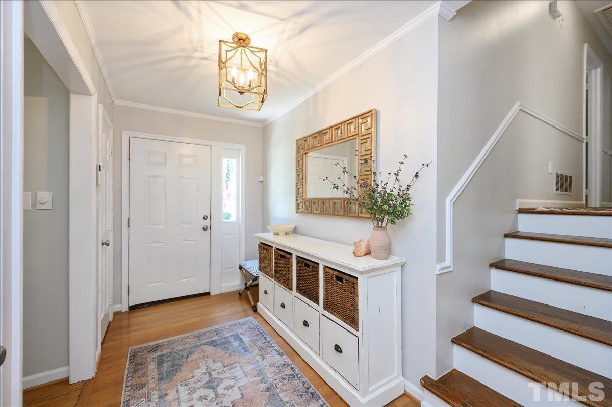 7509 Harps Mill Road Raleigh, NC 27615 - Photo 9 of 31 a view of a hallway with entryway and wooden floor
