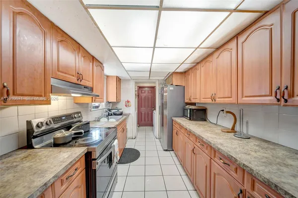 a kitchen with stainless steel appliances granite countertop a sink a stove and a wooden cabinets