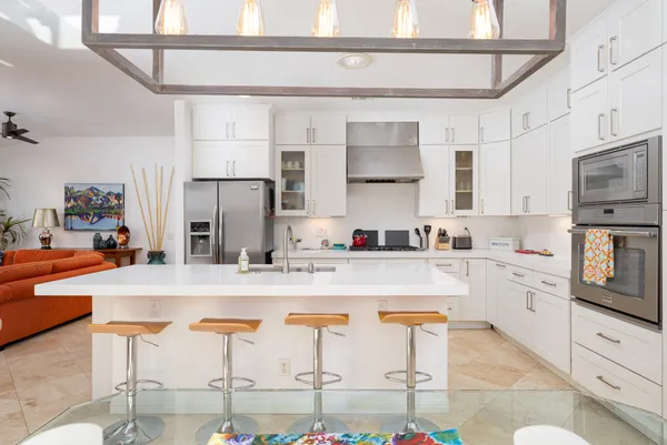 a kitchen with stainless steel appliances granite countertop a stove and white cabinets