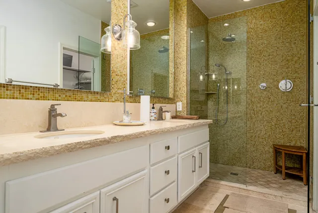a bathroom with a granite countertop sink mirror and shower