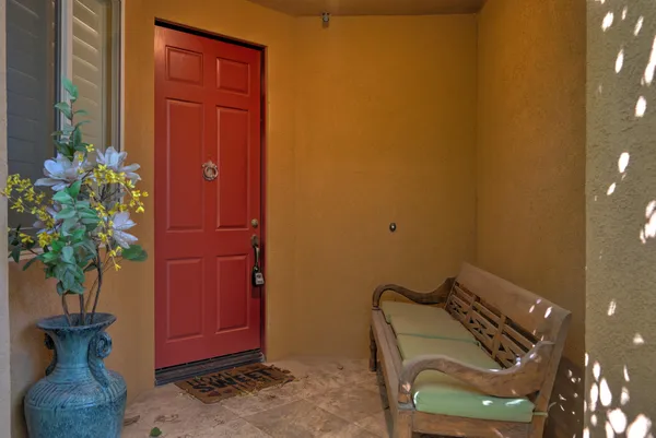 a wooden door with a chair and a potted plant