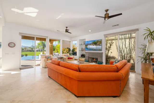 a living room with furniture a large window and a fireplace