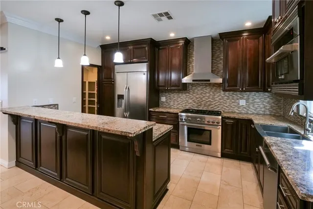 a kitchen with stainless steel appliances granite countertop a stove a sink and a refrigerator