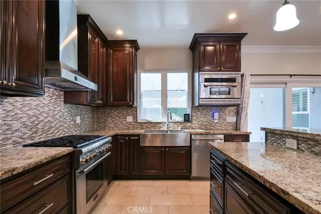 a kitchen with stainless steel appliances granite countertop a sink stove and oven