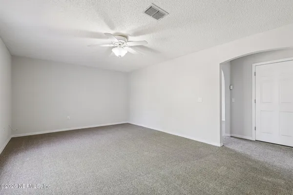 a view of a backyard with large trees and wooden fence