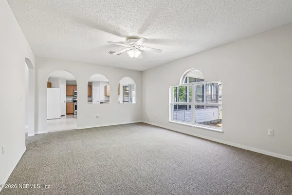 an empty room with a window and a fan