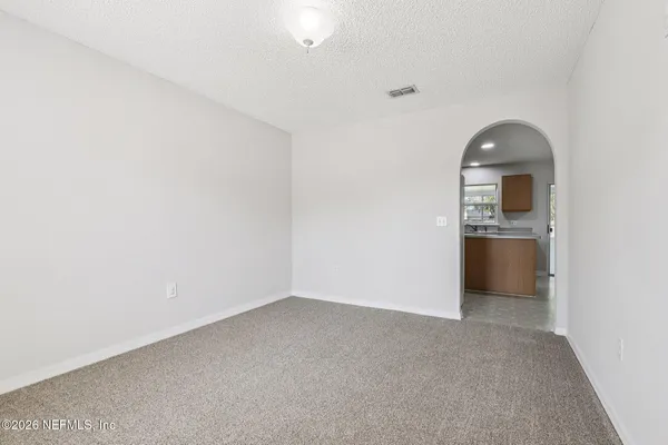 an empty room with a window and a ceiling fan