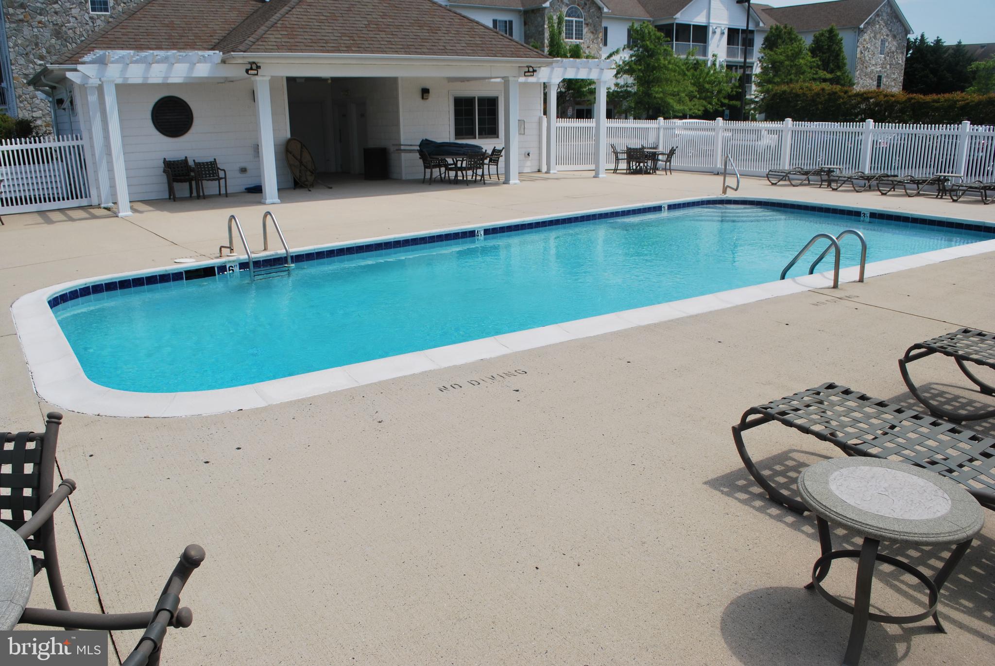 30609 Cedar Neck Road, Unit 3108 Ocean View, DE 19970 - Photo 39 of 42 a swimming pool with outdoor seating and yard