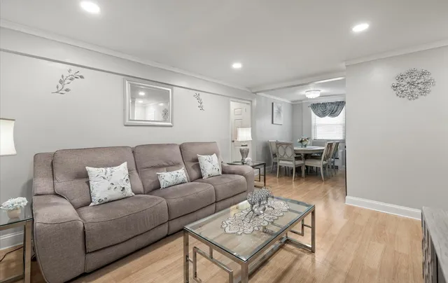 a living room with furniture a wooden floor and a ceiling fan
