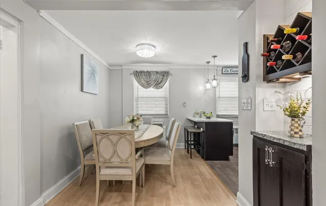 a dining room with wooden floor and stainless steel appliances