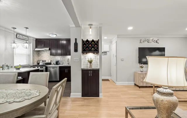 a kitchen with stainless steel appliances kitchen island granite countertop a refrigerator a stove a microwave oven a sink with island and chairs