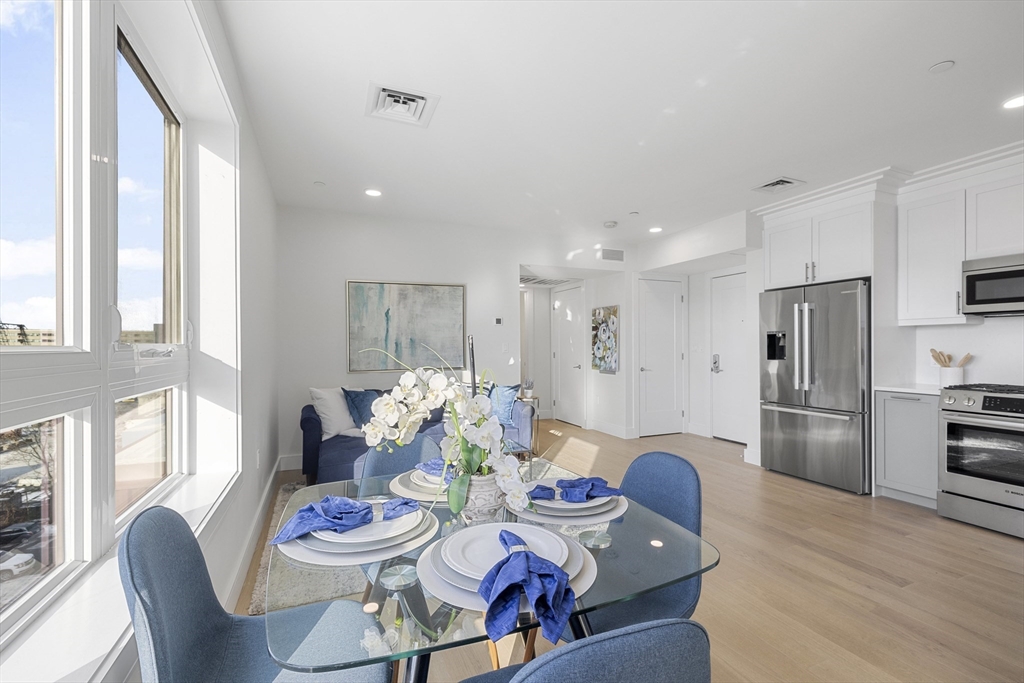 301 Border Street, Unit 611 Boston, MA 02128 - Photo 11 of 32 a kitchen with stainless steel appliances kitchen island granite countertop a dining table and chairs