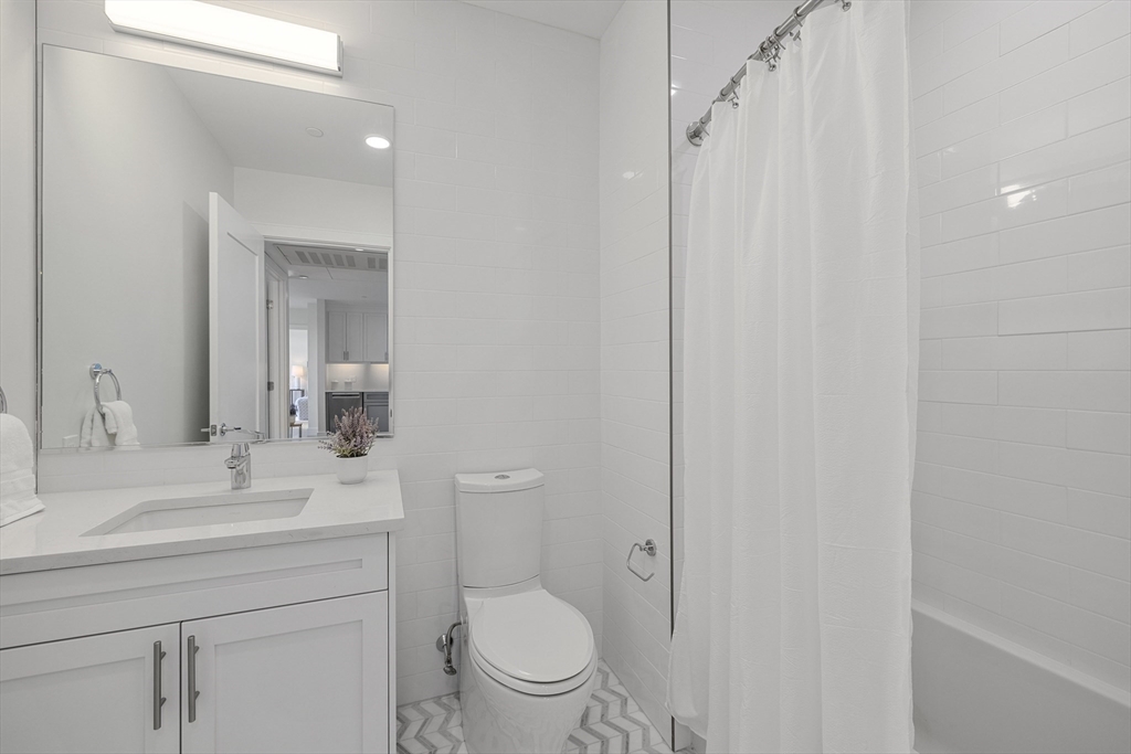 301 Border Street, Unit 611 Boston, MA 02128 - Photo 17 of 32 a bathroom with a toilet a sink and mirror