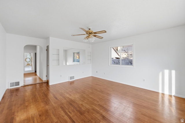 708 9th Street Ogden, UT 84404 - Photo 6 of 17 Spare room featuring ceiling fan, arched walkways, and wood finished floors
