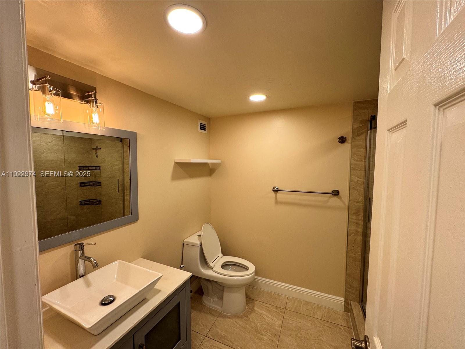 7928 West Drive, Unit 602 North Bay Village, FL 33141 - Photo 16 of 44 a bathroom with a toilet a sink and mirror