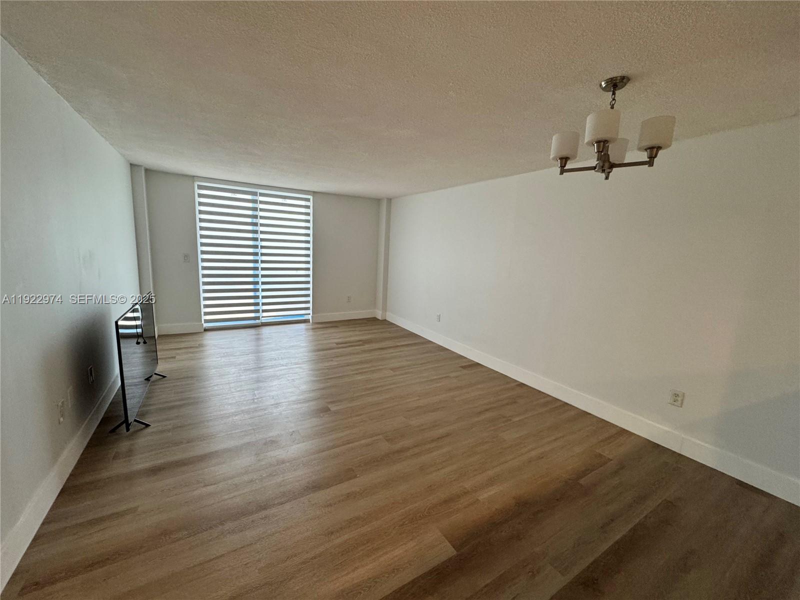 7928 West Drive, Unit 602 North Bay Village, FL 33141 - Photo 4 of 44 wooden floor in an empty room with a window