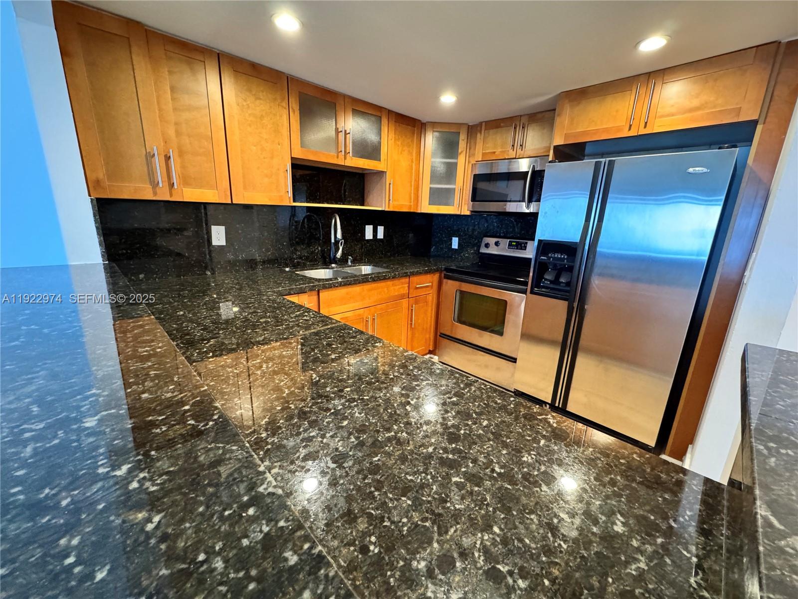 7928 West Drive, Unit 602 North Bay Village, FL 33141 - Photo 7 of 44 a kitchen with stainless steel appliances granite countertop refrigerator sink and stove