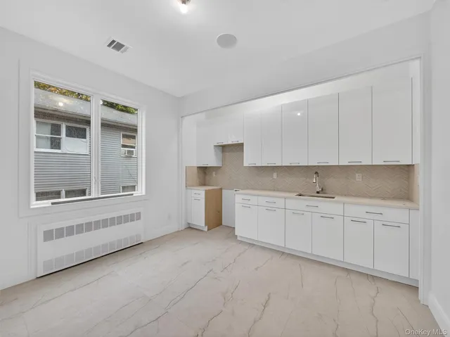 a kitchen with granite countertop white cabinets and white appliances