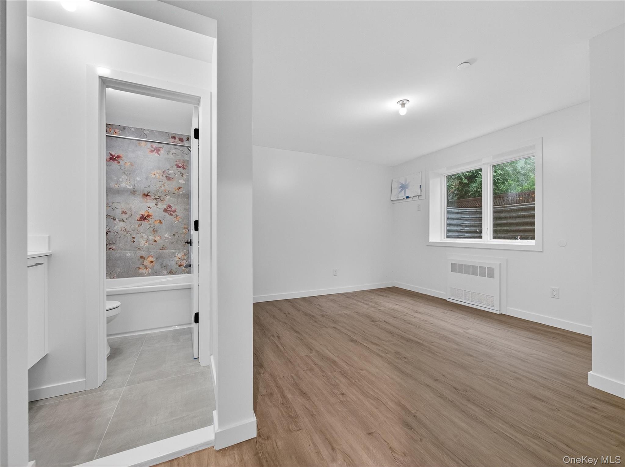 22 Johnson Street Spring Valley, NY 10977 - Photo 35 of 50 a view of an empty room with window and wooden floor