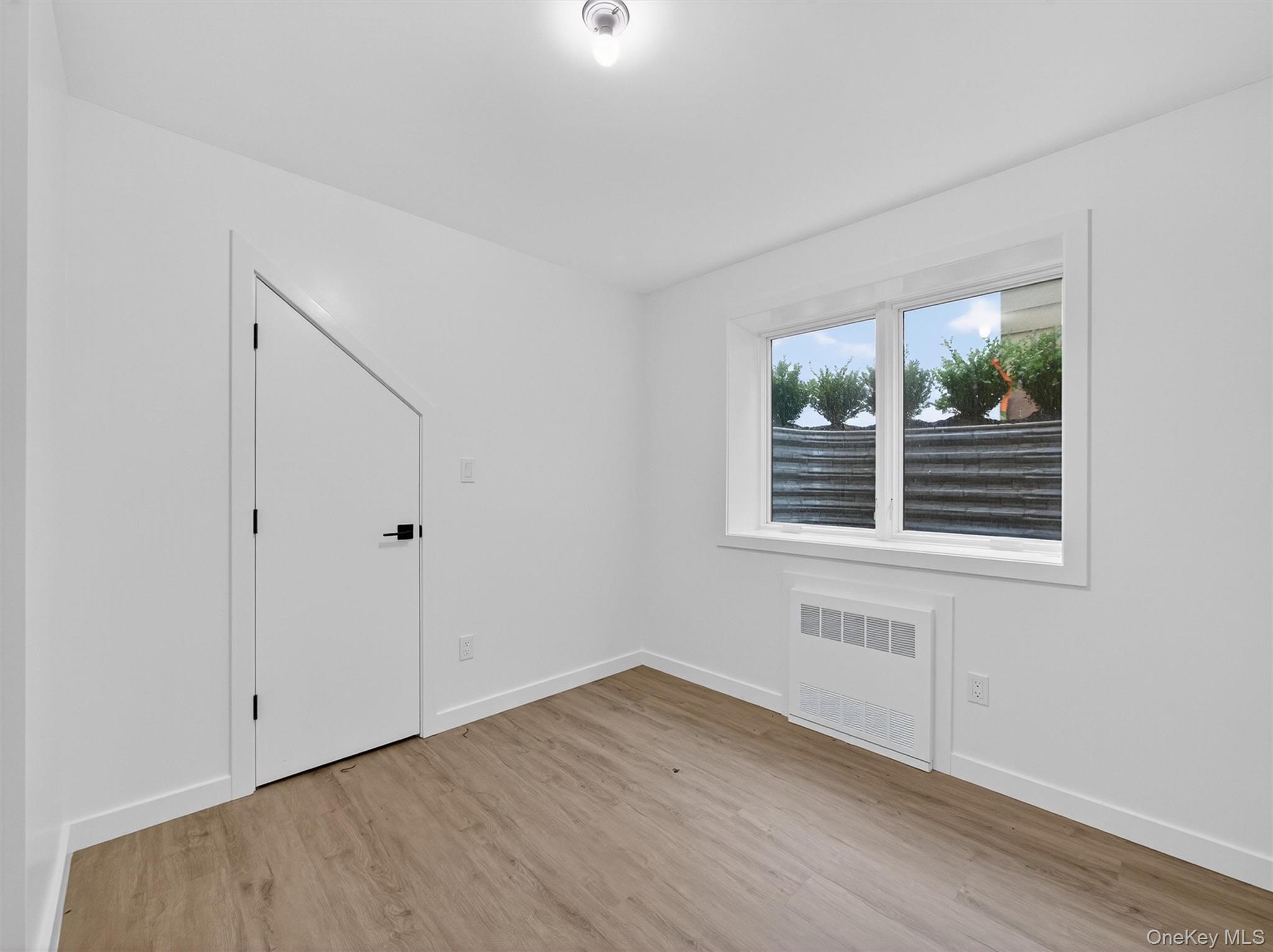 22 Johnson Street Spring Valley, NY 10977 - Photo 39 of 50 a view of an empty room with wooden floor and a window