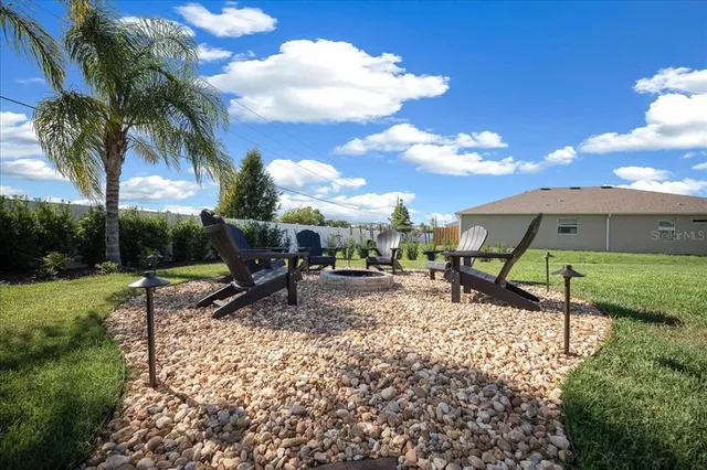 a large kitchen with stainless steel appliances kitchen island granite countertop a large counter top and view of a living room