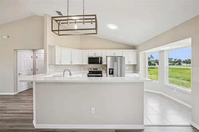 a kitchen with stainless steel appliances granite countertop a sink a stove and a refrigerator