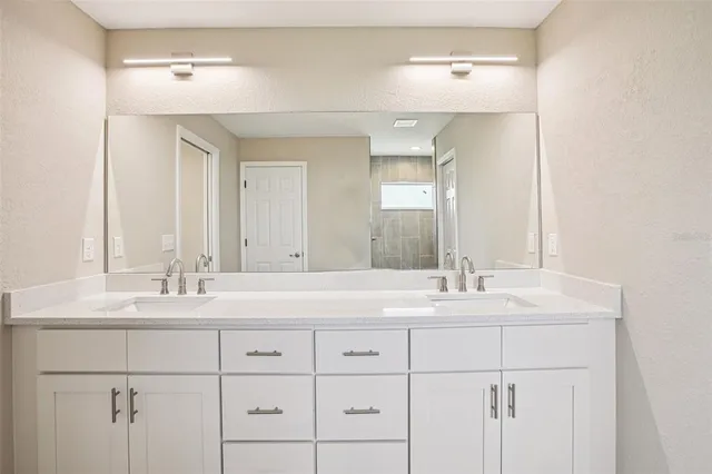 a bathroom with double sink and a mirror