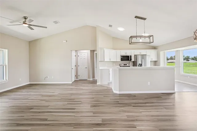 a view of kitchen with stainless steel appliances kitchen island sink stove and refrigerator