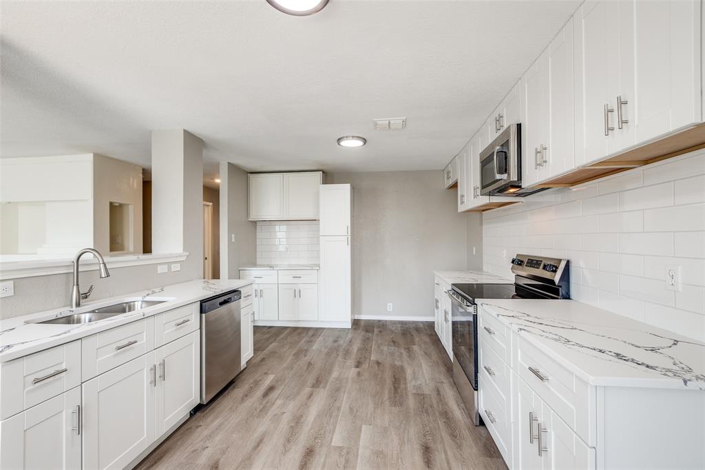 2624 Misty Harbor Drive Little Elm, TX 75068 - Photo 12 of 25 a kitchen with stainless steel appliances granite countertop a sink stove and refrigerator