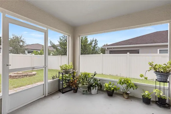 a backyard of a house with plants and wooden fence