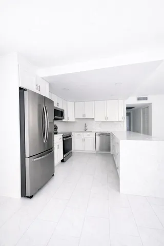 a kitchen with white cabinets and stainless steel appliances