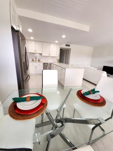 a kitchen with stainless steel appliances granite countertop a sink and a dining table