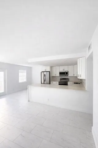 a view of kitchen with furniture and a refrigerator