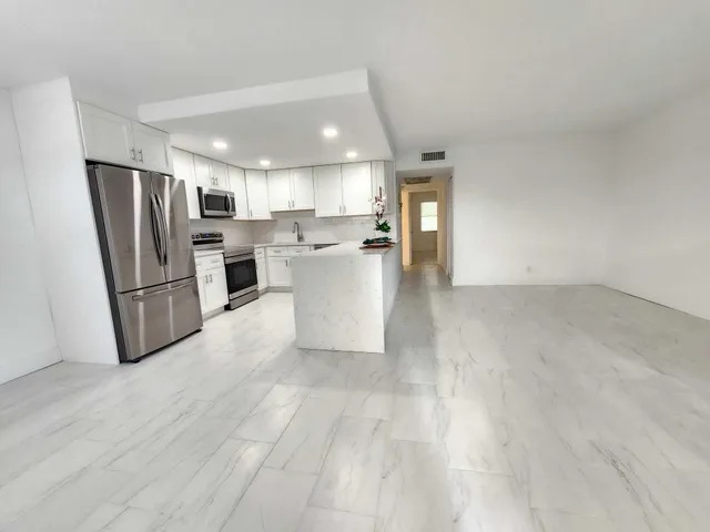 a view of kitchen with refrigerator stove microwave and cabinets