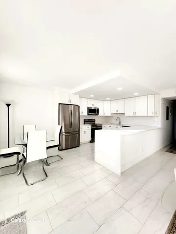 a view of kitchen with furniture and refrigerator