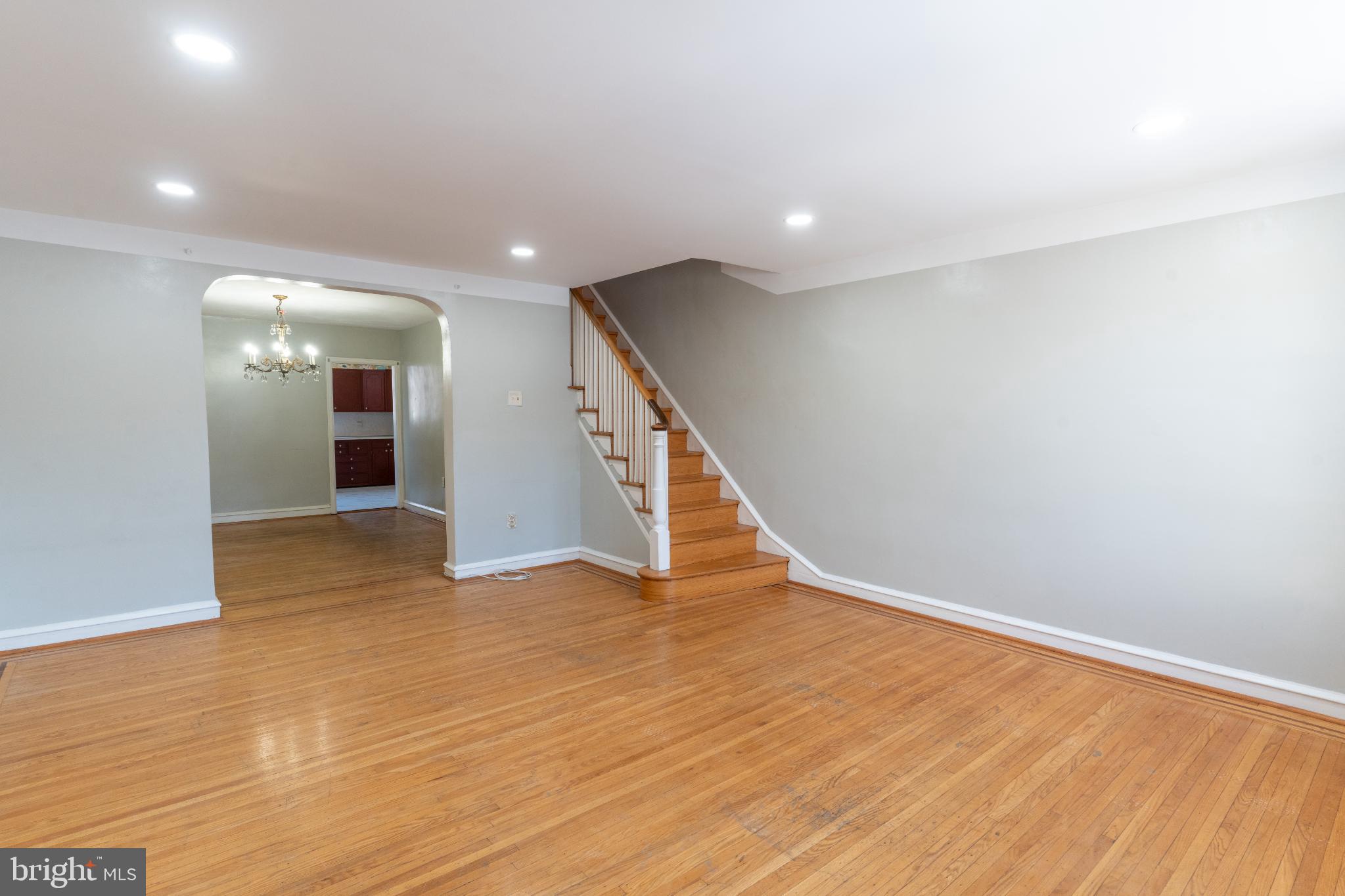 Spacious living area with elegant staircase.