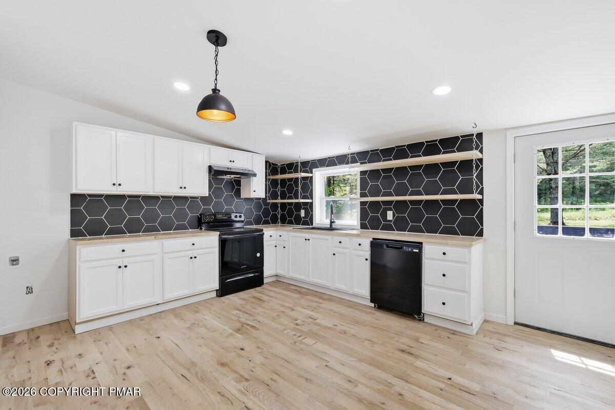 155 Blooming Grove Road Hawley, PA 18428 - Photo 16 of 41 a kitchen with stainless steel appliances granite countertop a stove and white cabinets with wooden floor