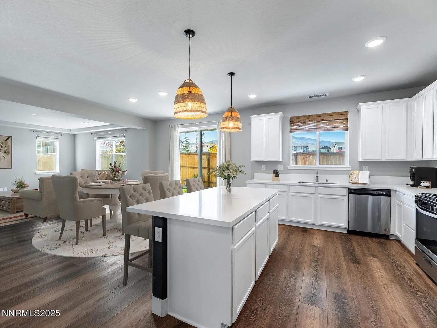 7731 Enclave Key Road Reno, NV 89506 - Photo 2 of 43 a large kitchen with kitchen island lots of counter space a sink appliances and a dining table