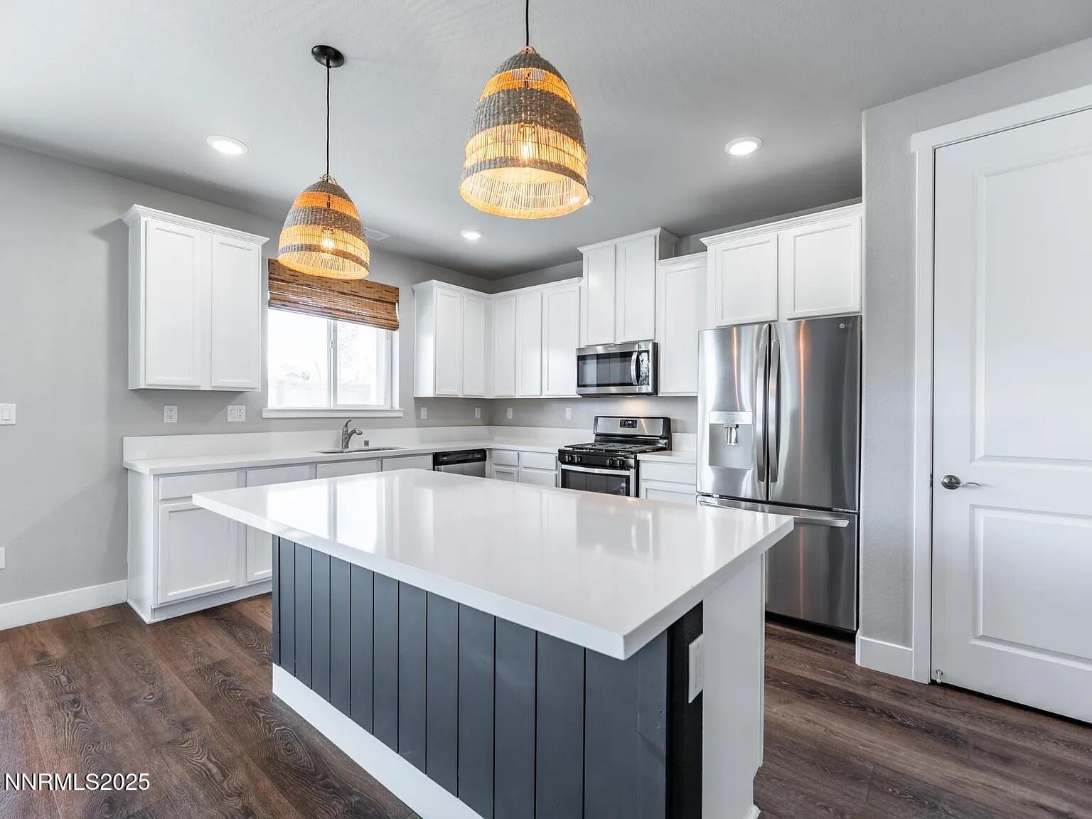 7731 Enclave Key Road Reno, NV 89506 - Photo 3 of 43 a kitchen with stainless steel appliances a stove a refrigerator a sink and a center island
