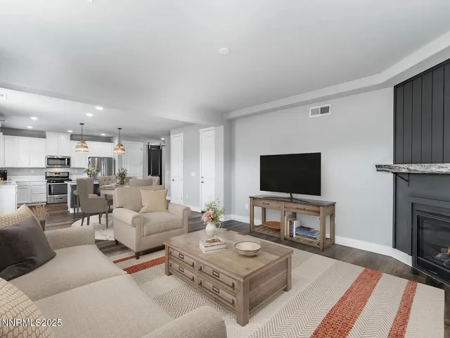 a living room with furniture a flat screen tv and kitchen view