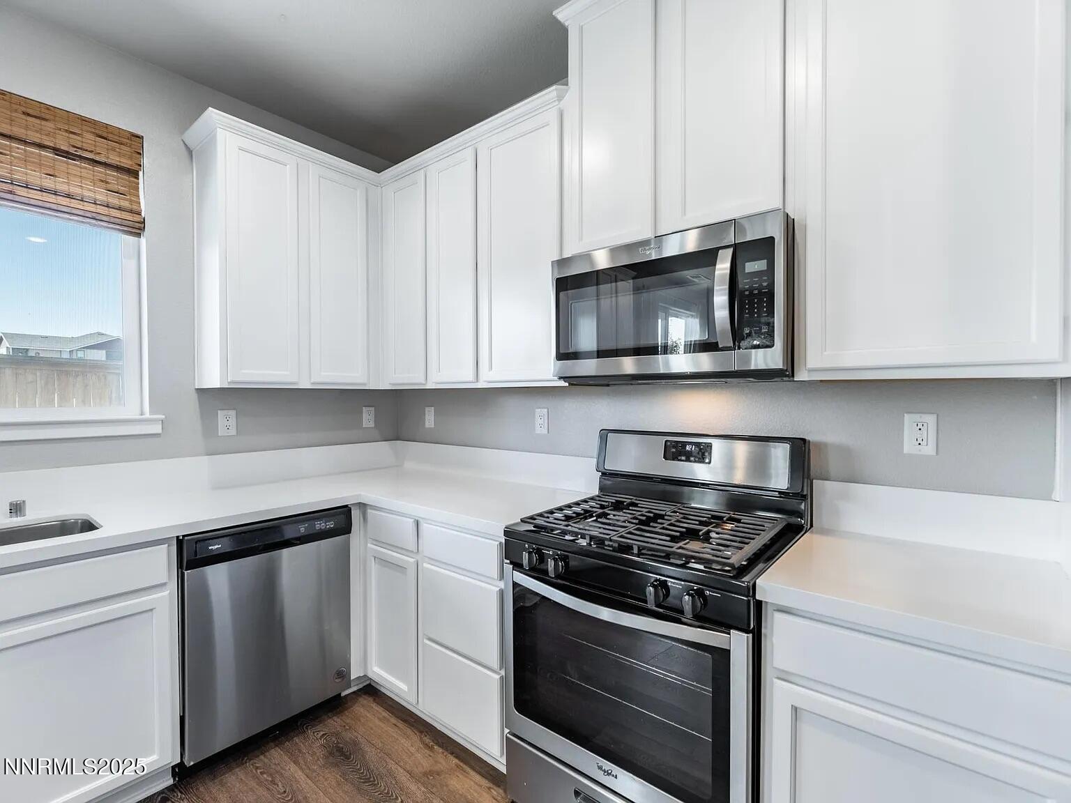 7731 Enclave Key Road Reno, NV 89506 - Photo 6 of 43 a kitchen with white cabinets and stainless steel appliances