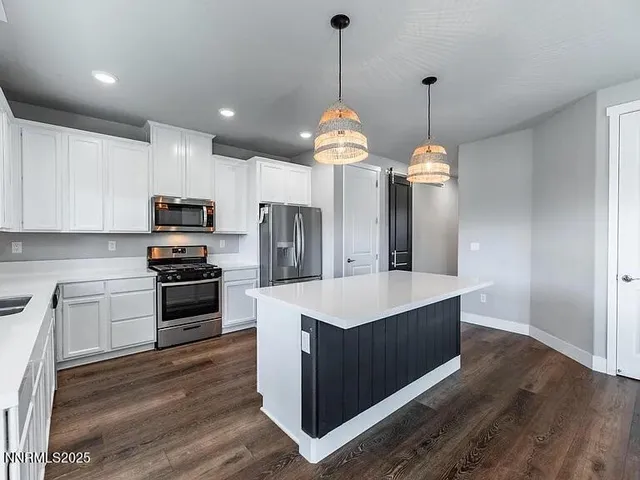 a kitchen with kitchen island a sink stainless steel appliances and cabinets