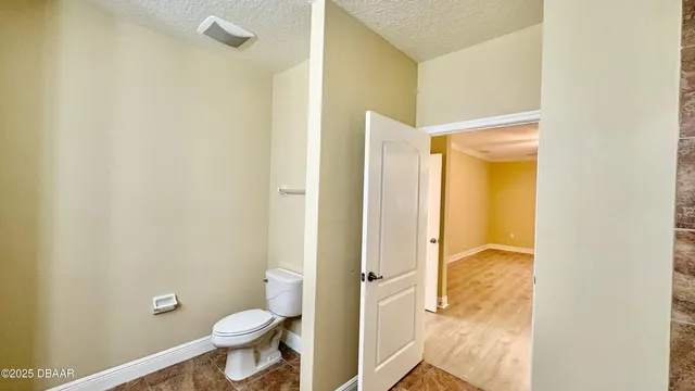 a bathroom with a granite countertop toilet and a sink