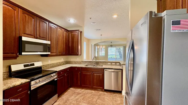 a kitchen with stainless steel appliances granite countertop a refrigerator stove microwave and sink