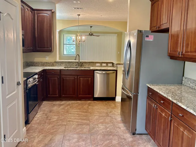 a kitchen with stainless steel appliances granite countertop a refrigerator and a sink