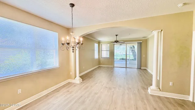 a view of a room with wooden floor fan and windows