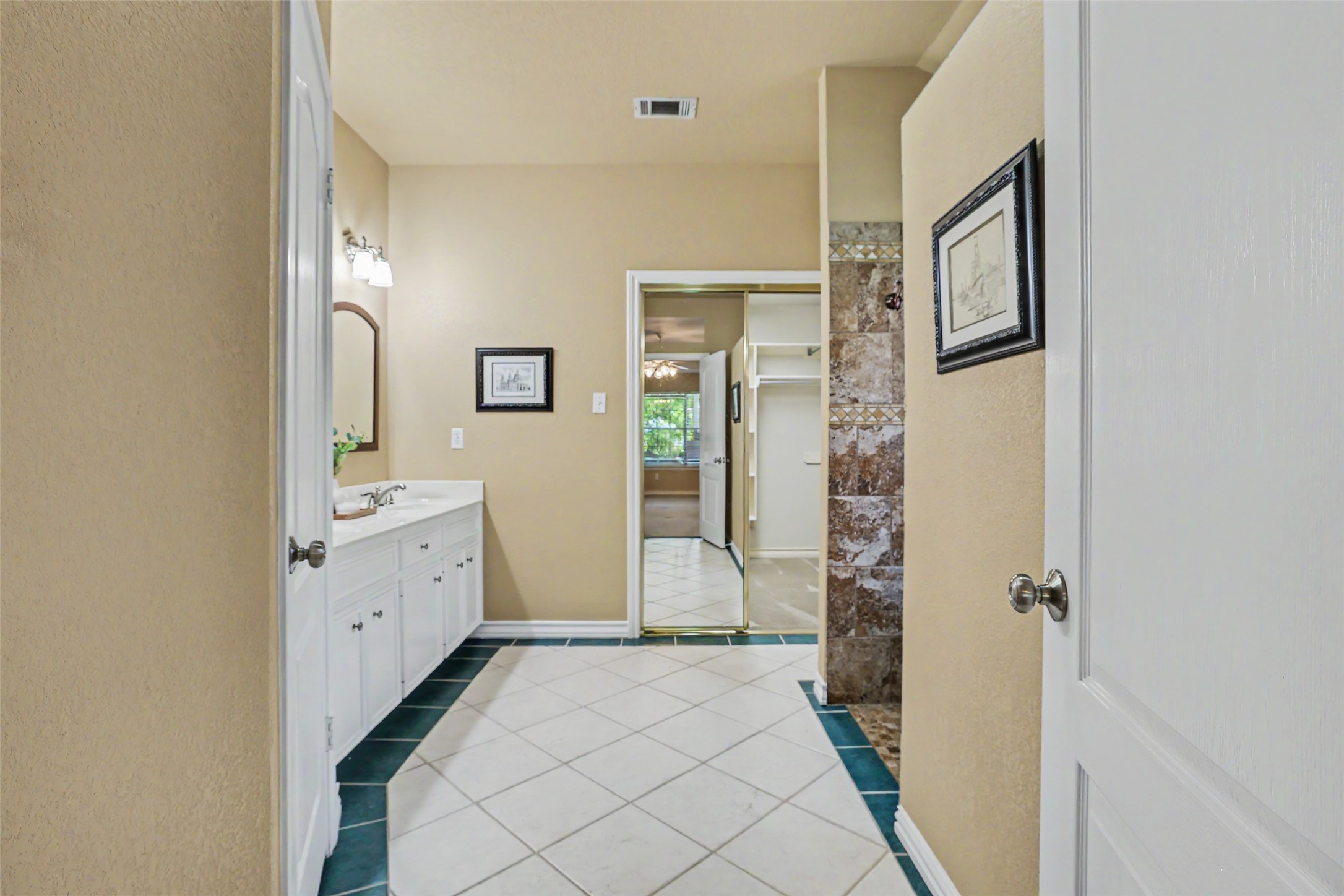 30107 Hamlet Circle Georgetown, TX 78628 - Photo 16 of 40 A generously sized bathroom features a dual vanity and a spacious walk-in shower with stone tile.