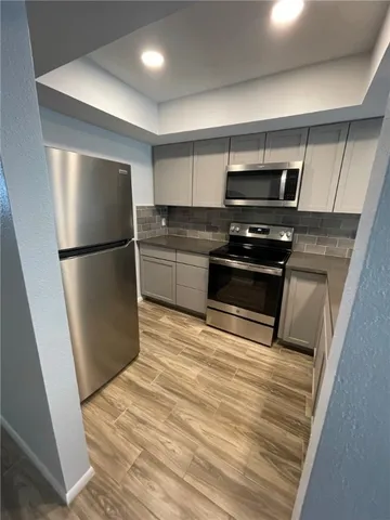 a kitchen with a refrigerator and a stove