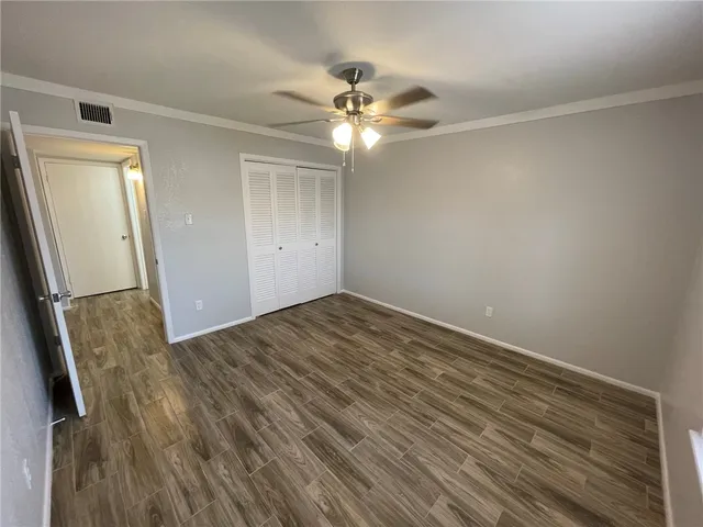 a view of a livingroom with wooden floor and a ceiling fan